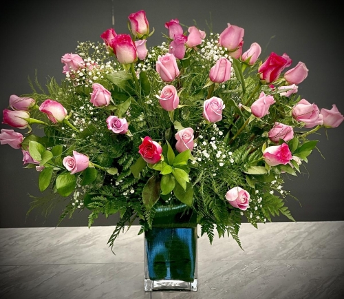 4 Dozen Roses arranged in a Glass Vase.